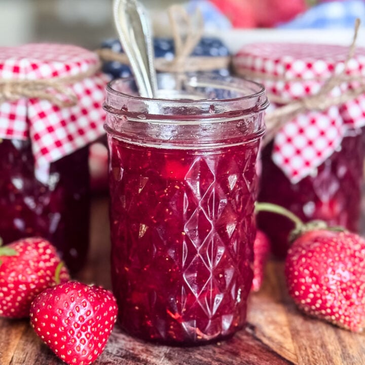 jar of homemade strawberry jam with a spoon in jar