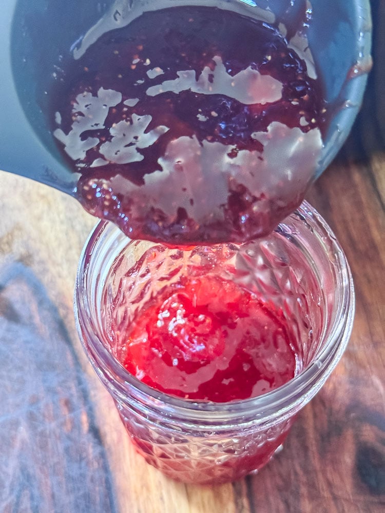 filling a jam jar with strawberry jam