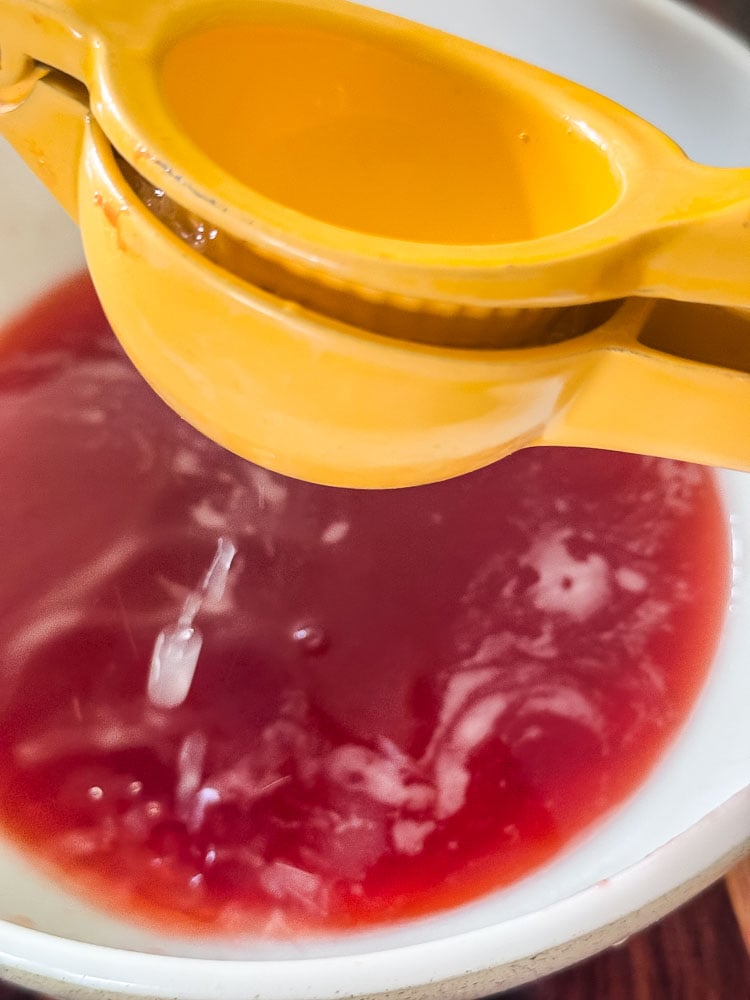 adding lemon juice to strawberry syrup