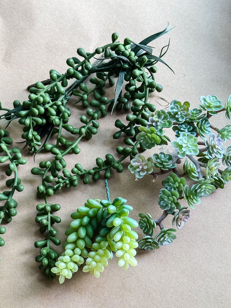 a pile of artificial succulents on brown paper