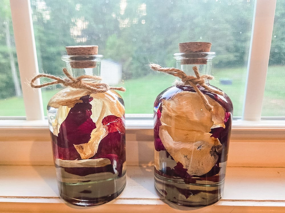 glass bottles filled with rose petals suspended in oil