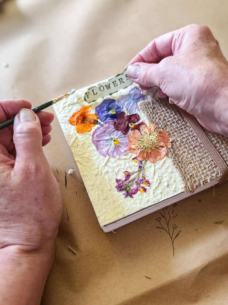 a woman making a flower journal