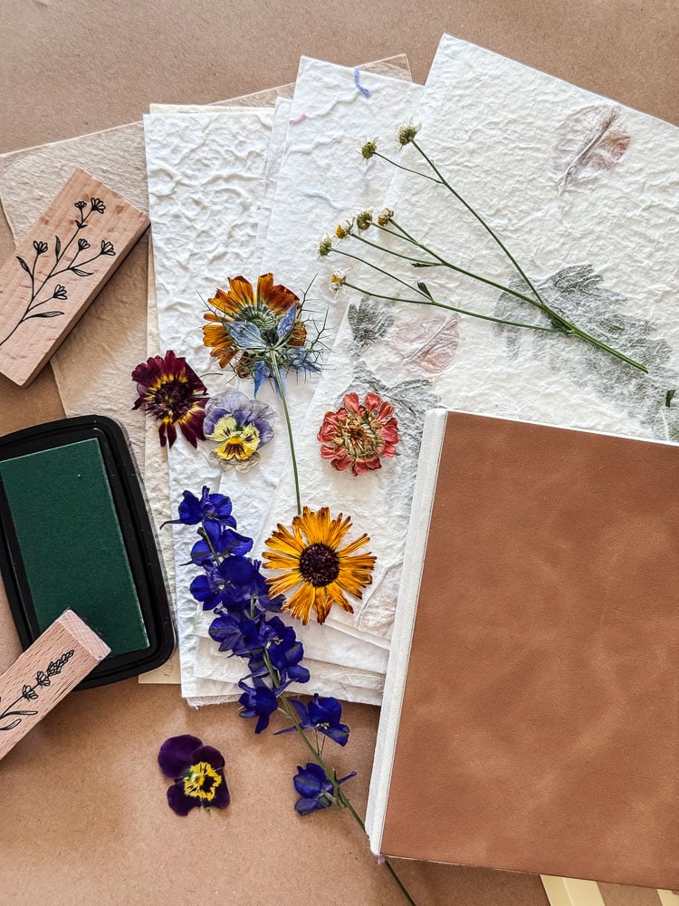 a flatlay of supplies being used to make a handmade flower journal