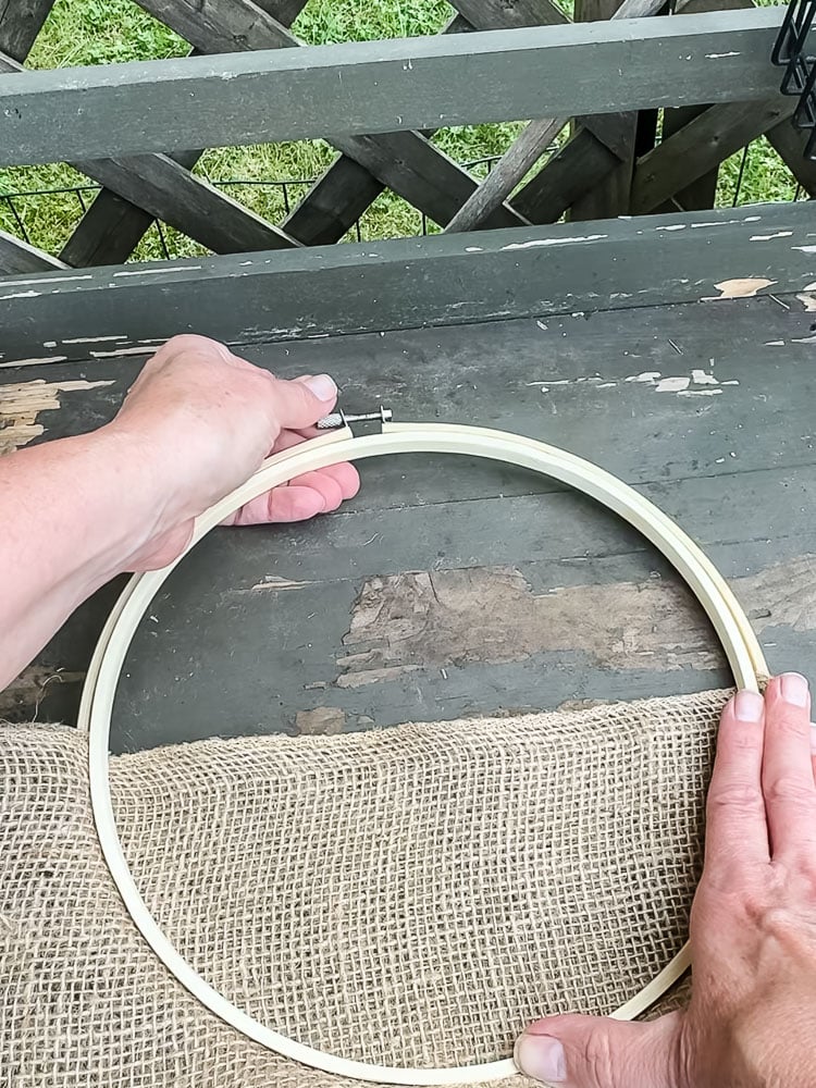 a woman's hands closing an embroidery hoop