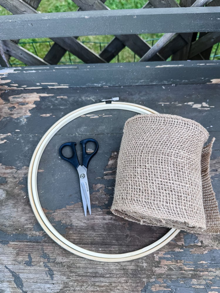 embroidery hoop, roll of burlap ribbon, scissores