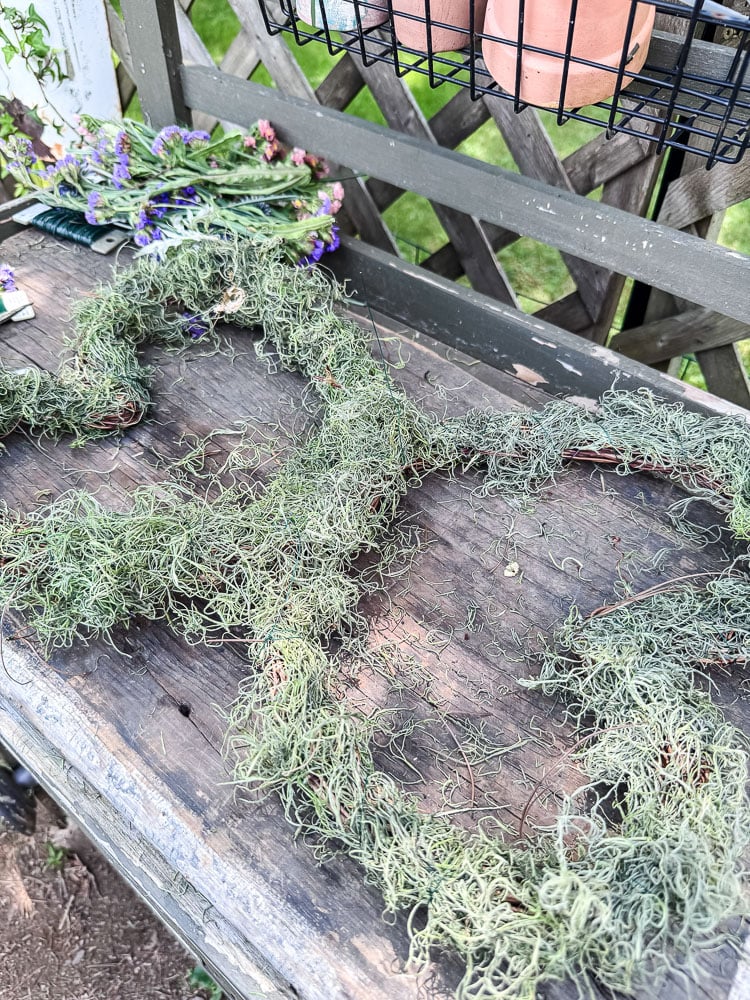 butterfly shaped wreath with green spanish moss covering it