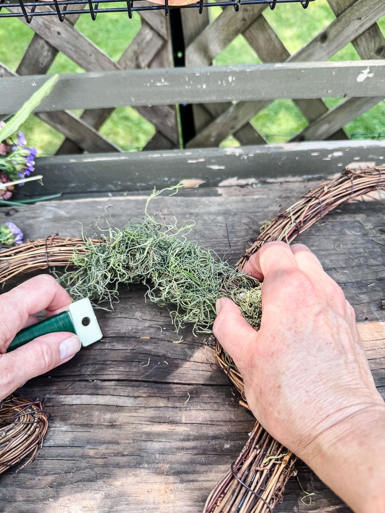 covering grapevine wreath form with green moss