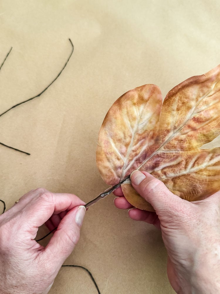 a woman holding an artifiical leaf and branch
