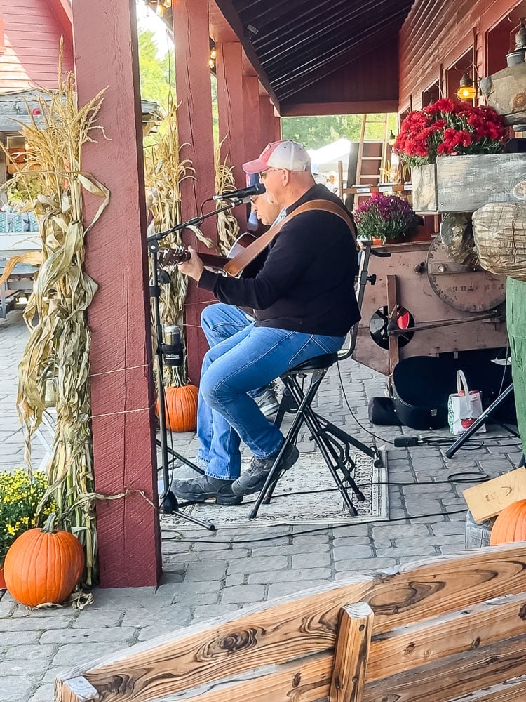 men outdoors playing music at a fall fair