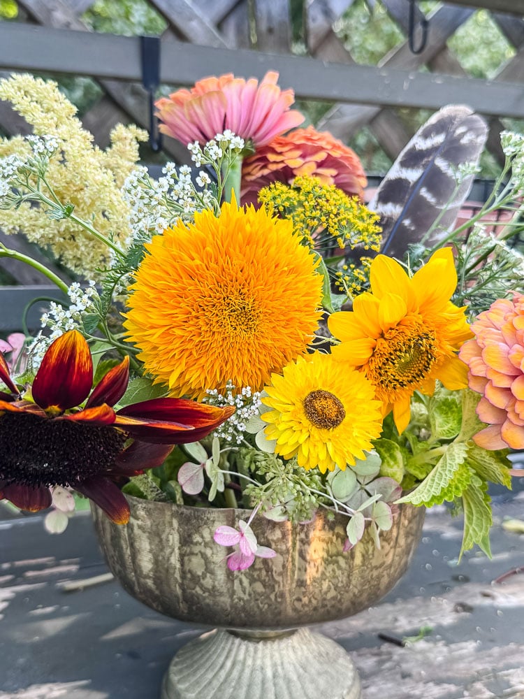flower arrangement with yellow sunflowers, zinnias. and pink and red flowers