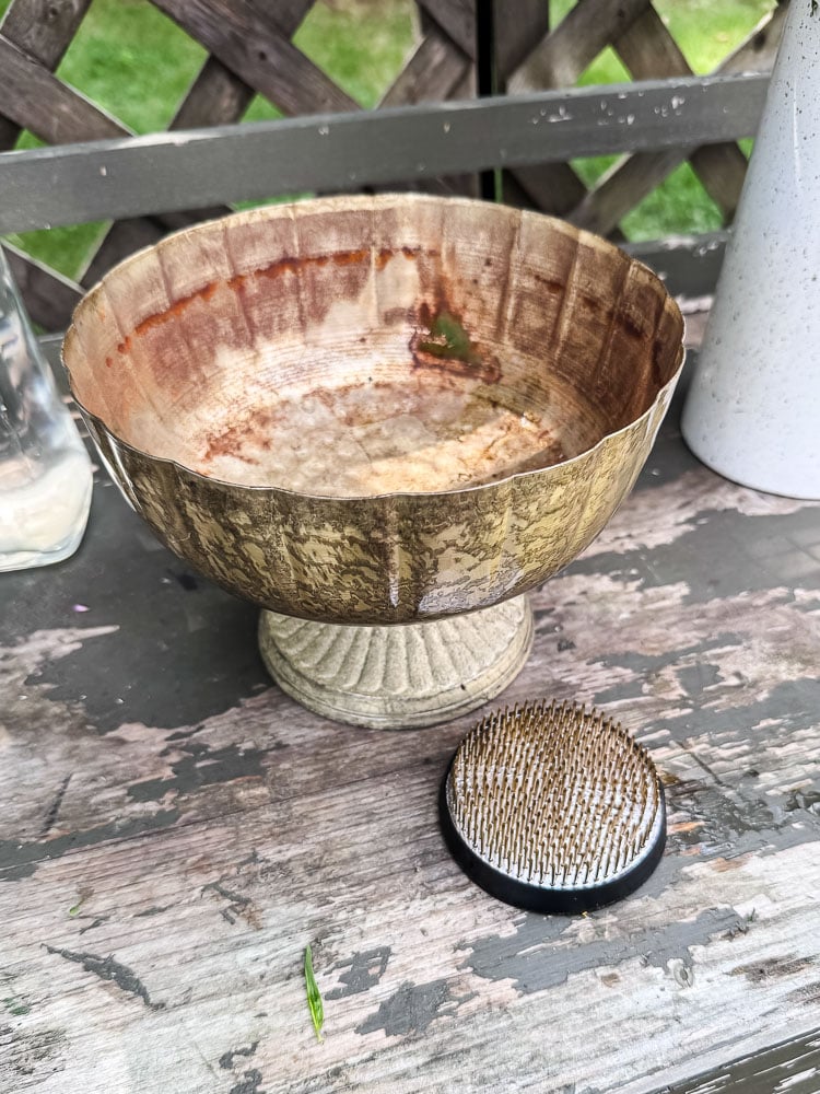 brass footed compote and flower frog on outdoor table