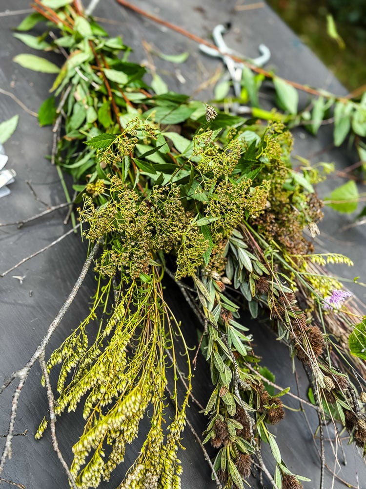 a bundle of foraged materials including branches and wildflowers
